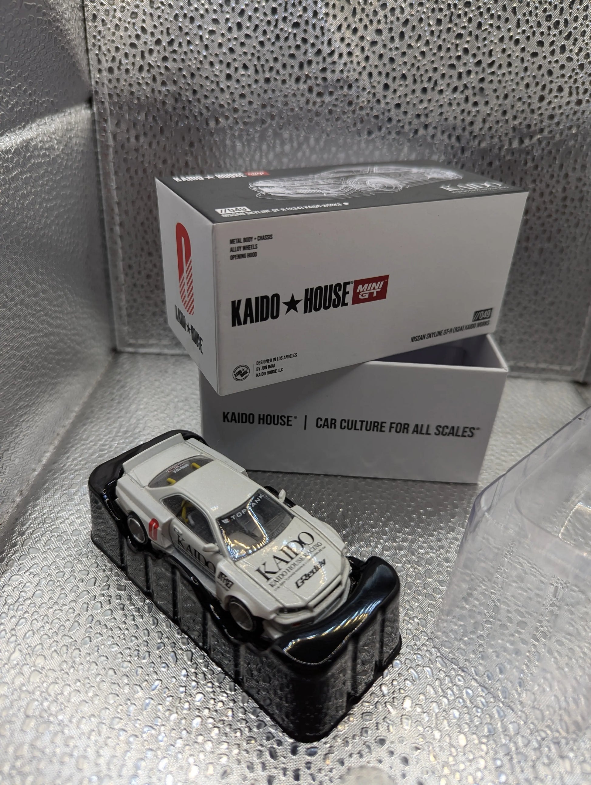 Kaido House x Mini GT Nissan Skyline GT-R R34 Works V1 KHMG049 1/64 WHITE FRENLY BRICKS - Open 7 Days